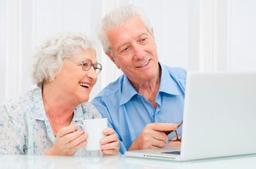 Adultos mayores utilizando computador 